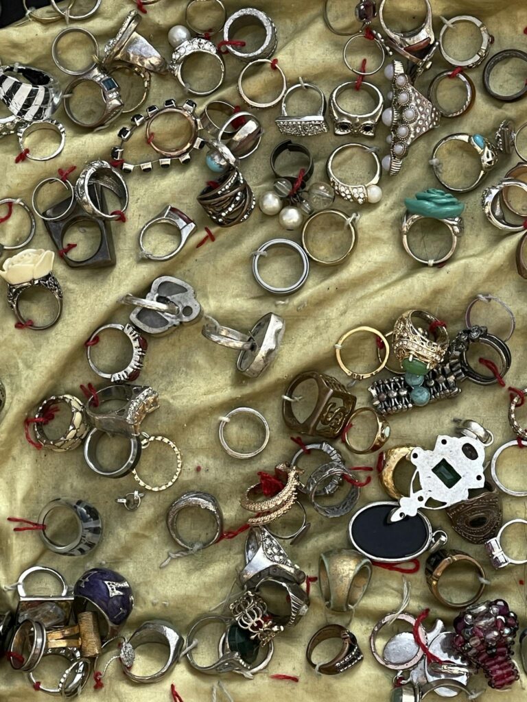 Assorted rings of various designs and materials on a golden background.